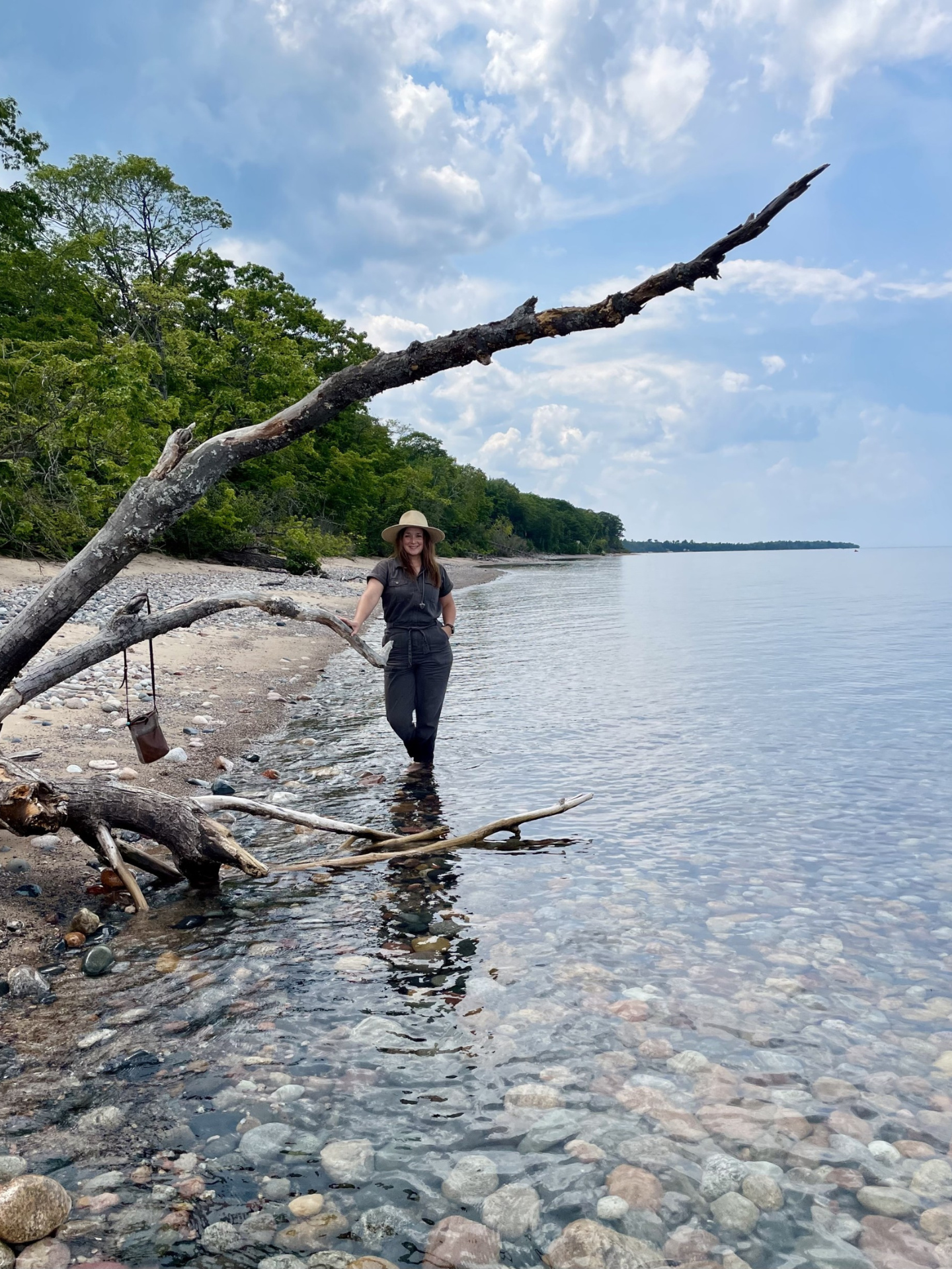 Allyson Drumhiller by a large piece of driftwood by the lake